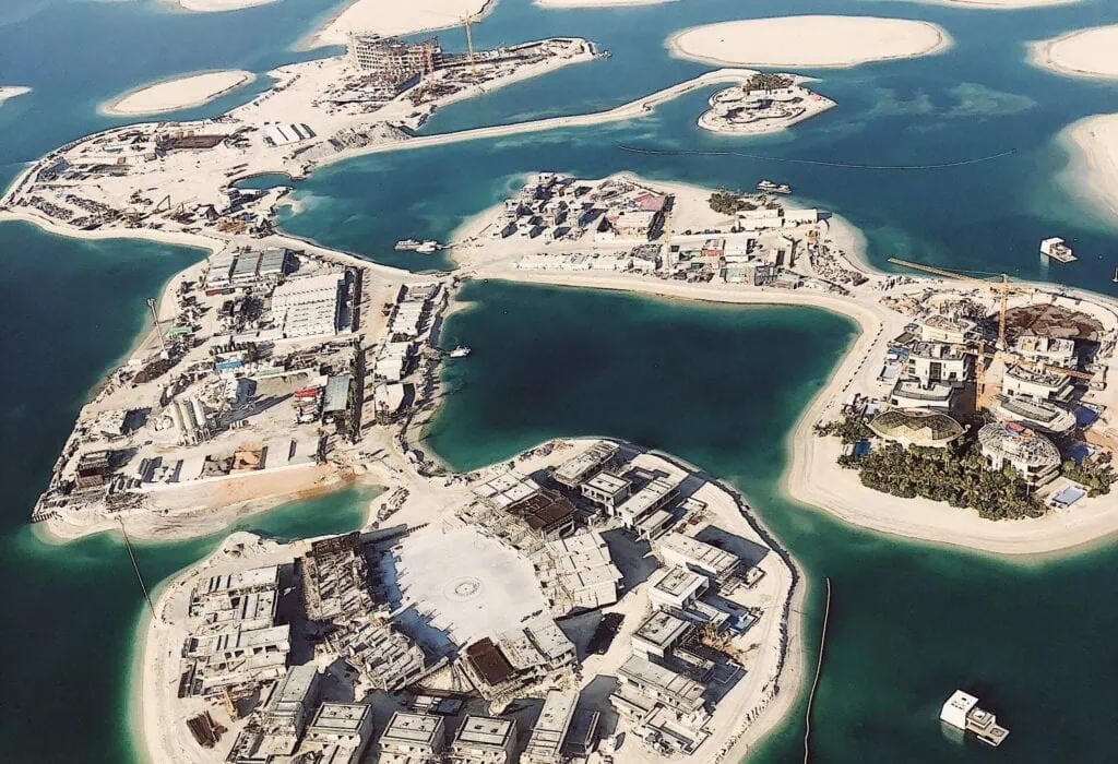 The World Islands artificial archipelago showing clustered sandy islands with construction sites, cranes, and waterfront villas in Dubai