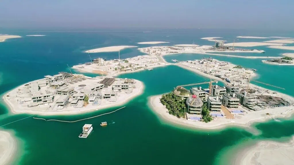 The World Islands artificial archipelago with sandy islets, villas, and construction sites surrounded by turquoise water in Dubai