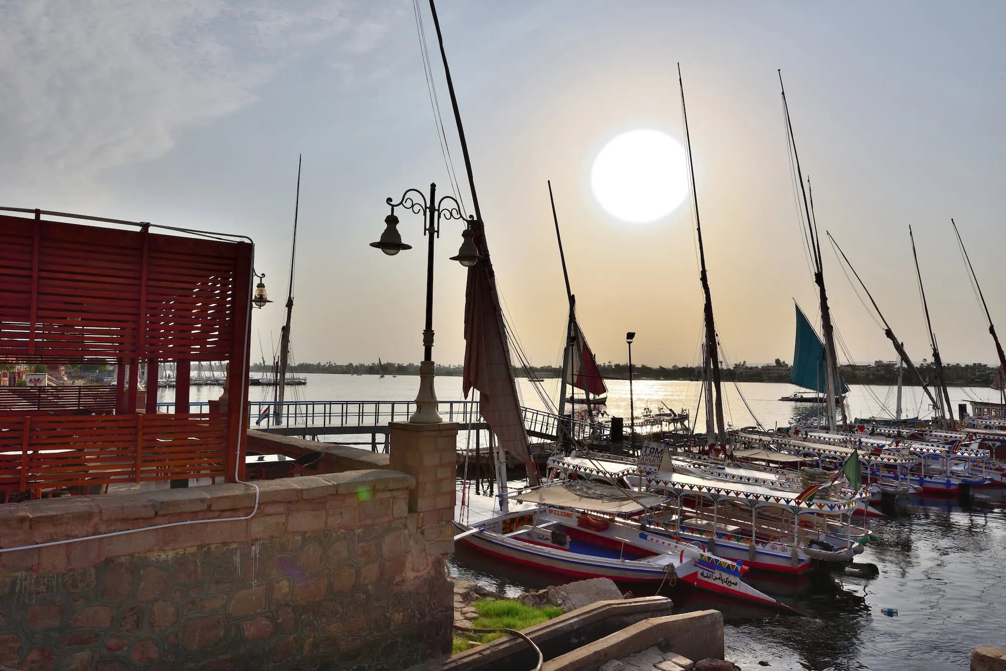 Felucca sailboats on the Nile River waterfront in Aswan at sunset