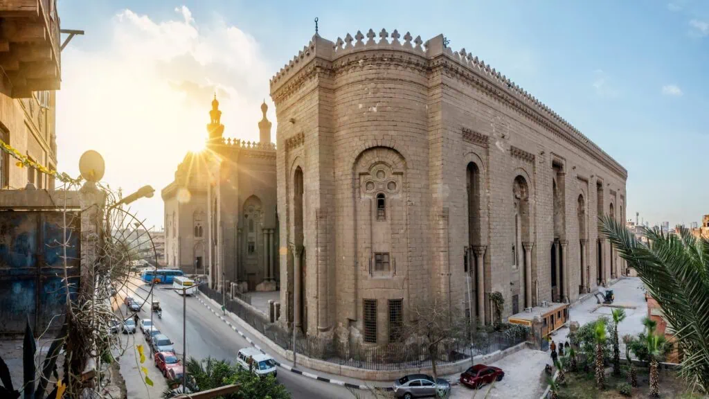 High stone walls with carved architectural details and monumental scale at the Sultan Hassan Mosque-Madrassa, Cairo