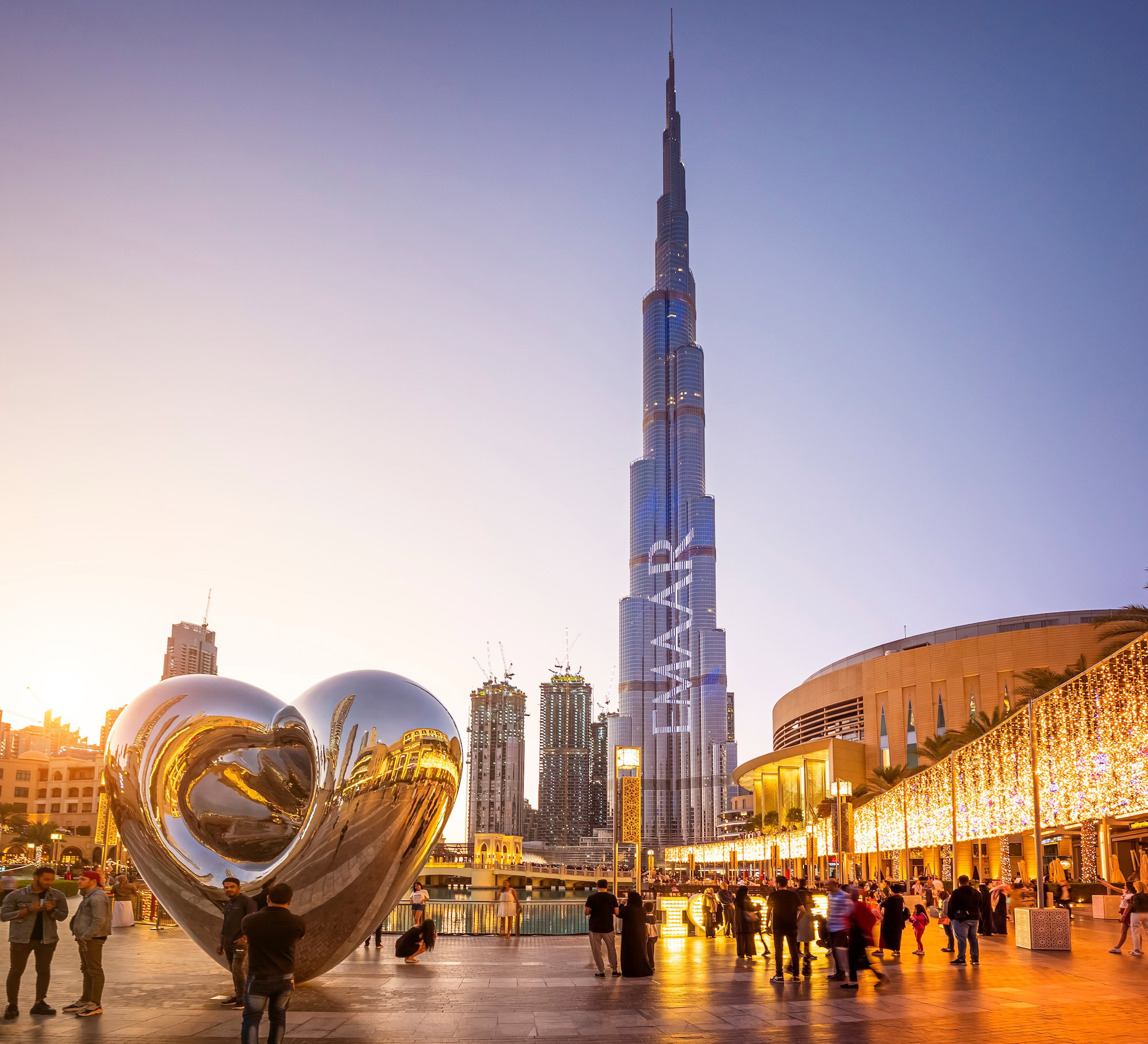 Burj Khalifa tower with heart sculpture and shopping mall plaza in Dubai