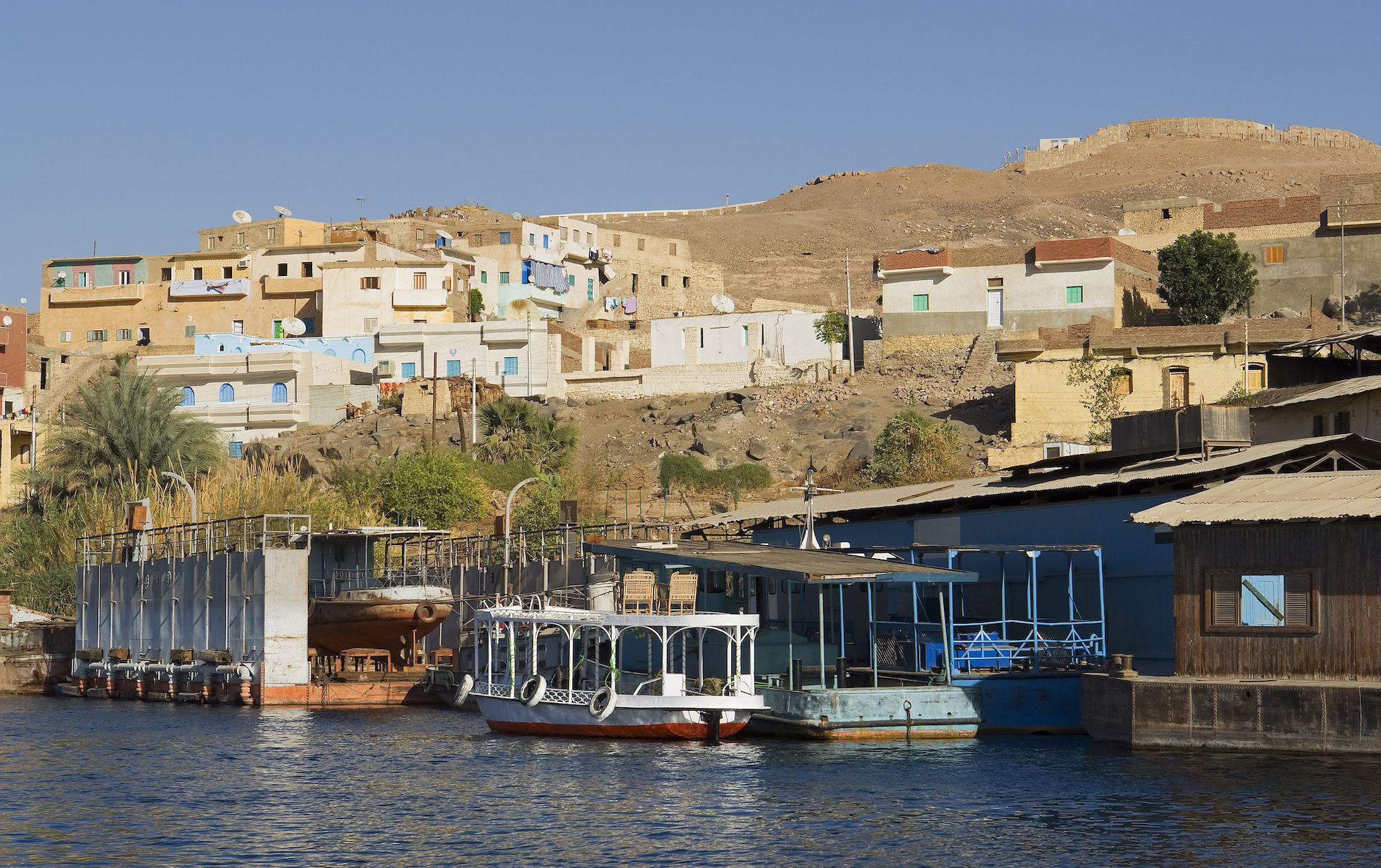 Nile River village with traditional boats docked along the riverbank
