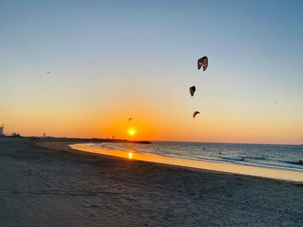 Three kites against a setting sun on Kite Beach, Dubai