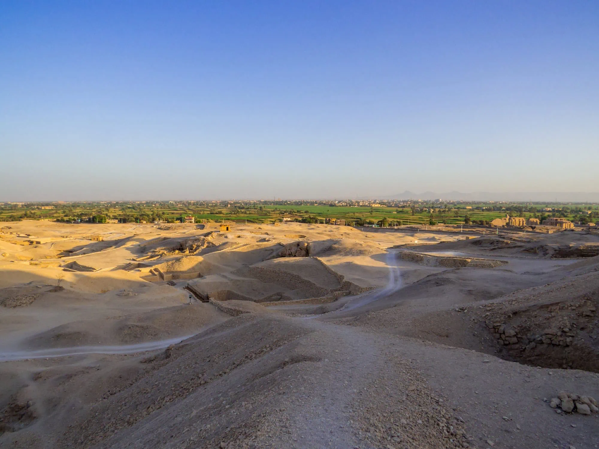 Archaeological excavation site in Egypt showing ancient ruins and excavation pits