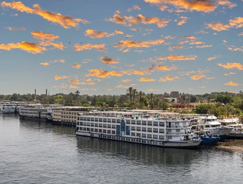 Tourist cruise ships on the Nile river anchored in the tourist port. Sunset light