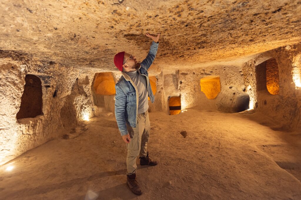 Tourist man in Kaymakli underground city ancient cave in Cappadocia