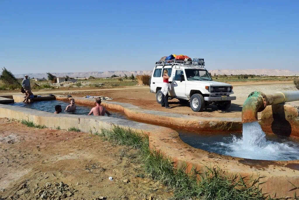 Tourists bathing at Bir Setta hot artesian spring in Farafra Oasis