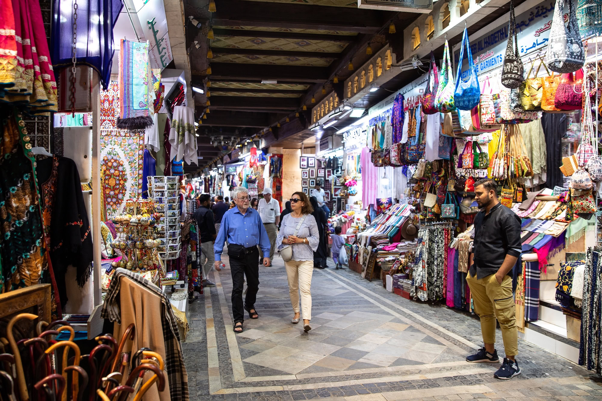 Traditional Middle Eastern bazaar with colorful textiles, souvenirs, and shops under stone archways