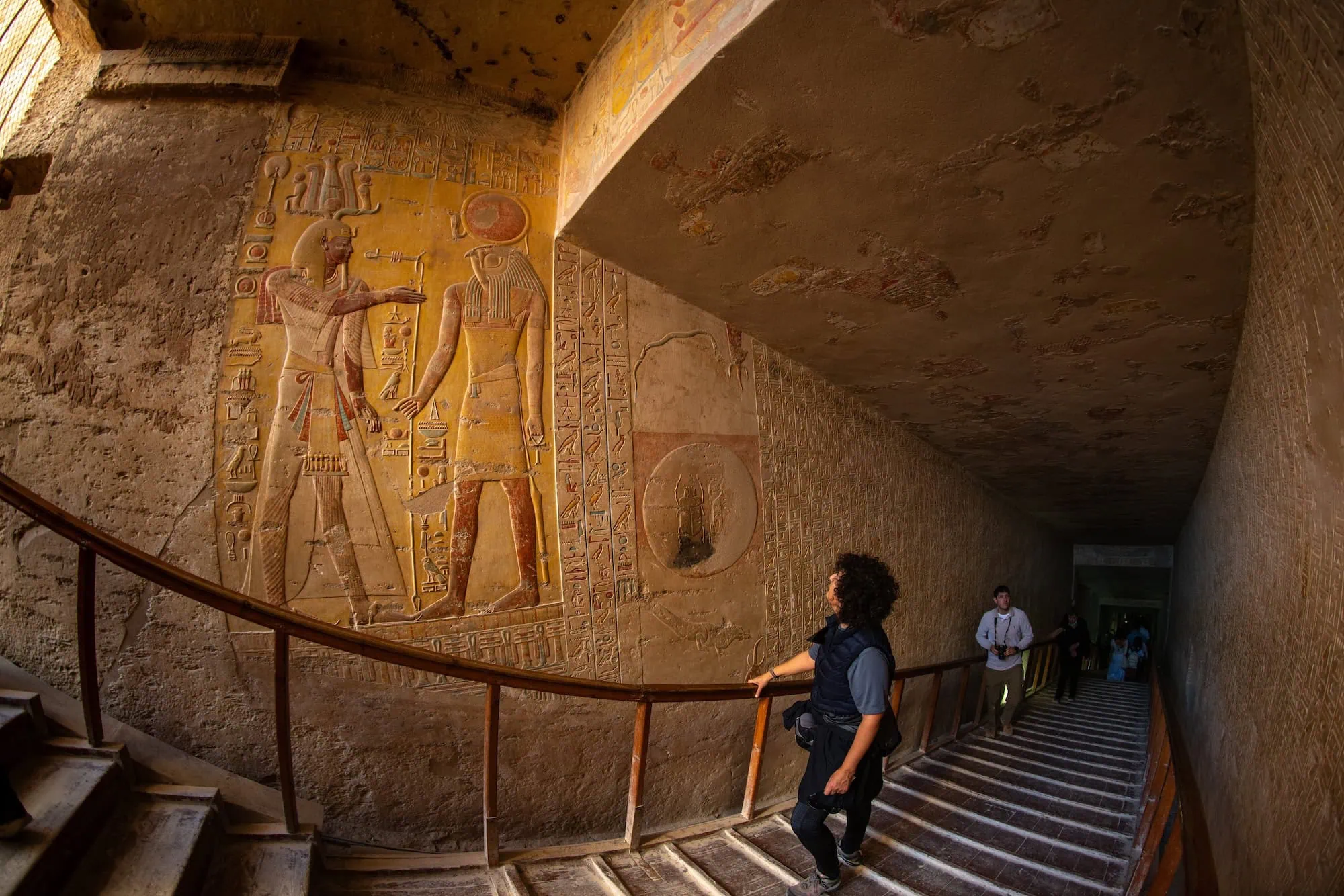Ancient Egyptian tomb interior with hieroglyphic wall carvings and stone staircase