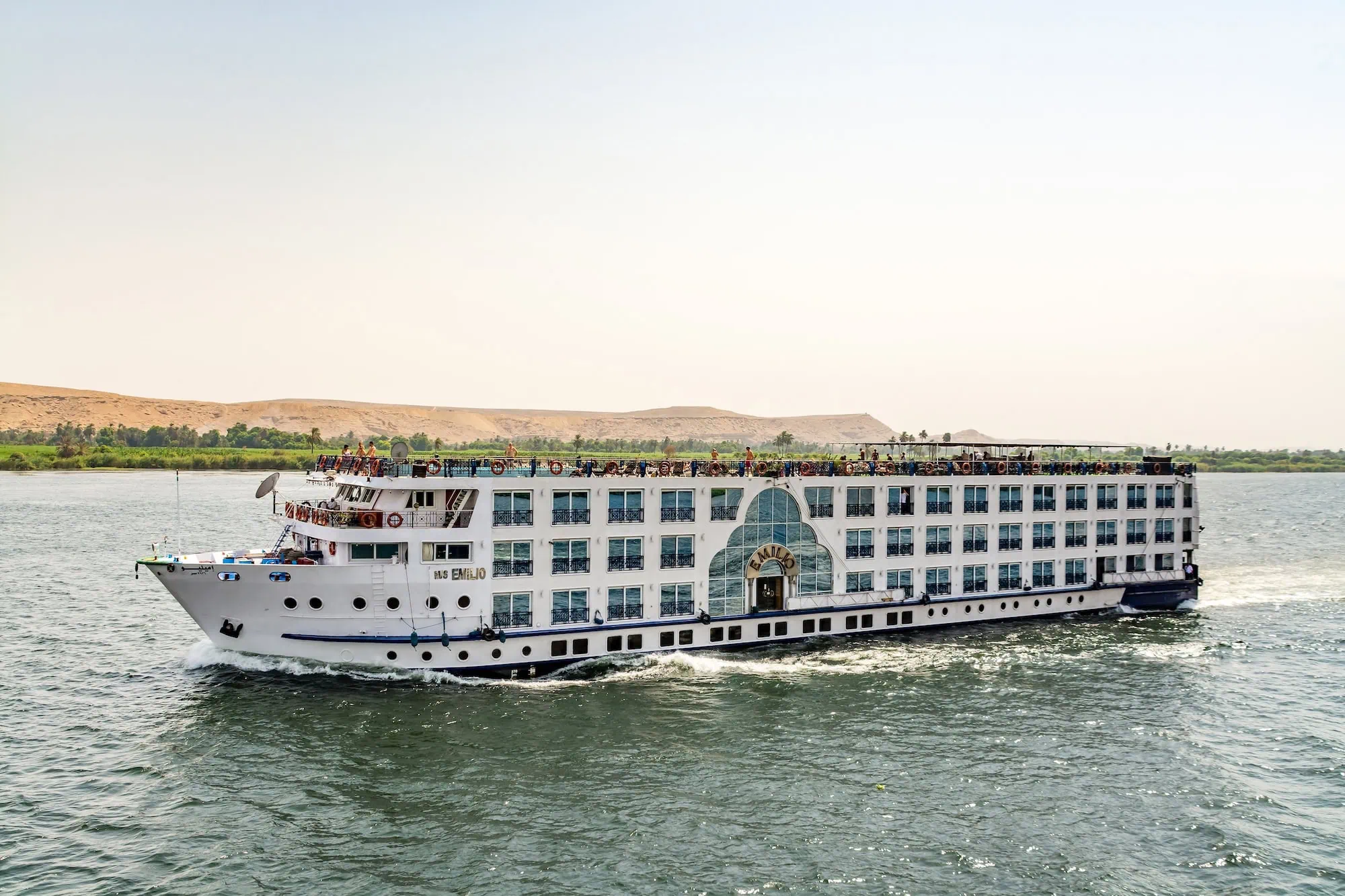 Nile River cruise ship sailing through Egyptian desert landscape