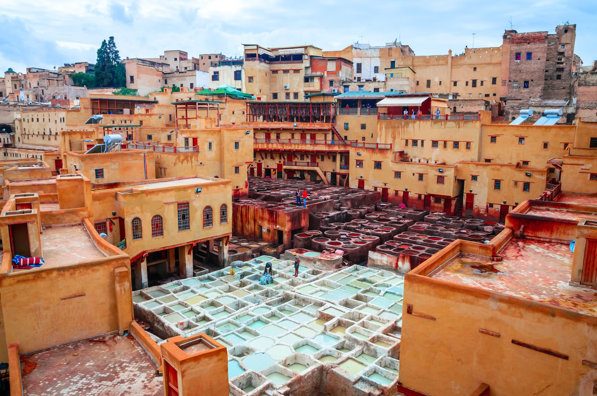 Aerial view of Chouara tannery's colorful dyeing vats and traditional rooftops in Fez, Morocco