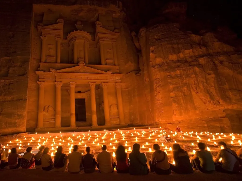 Al-Khazneh (The Treasury) at Petra in Jordan illuminated by hundreds of candles during the Petra by Night experience, with the rose-red sandstone facade glowing in warm light