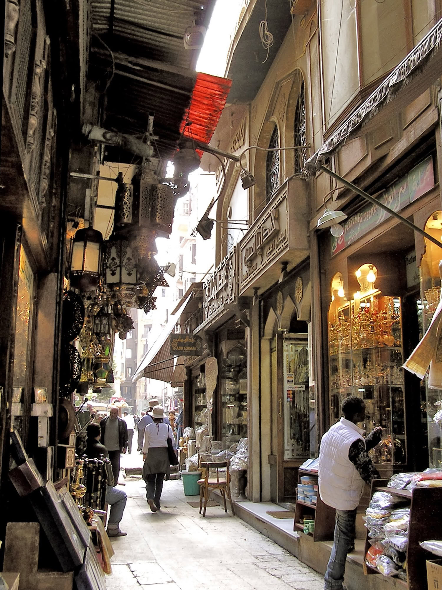 Bustling narrow alley in Khan el-Khalili bazaar with traditional shops, lanterns, and vendors