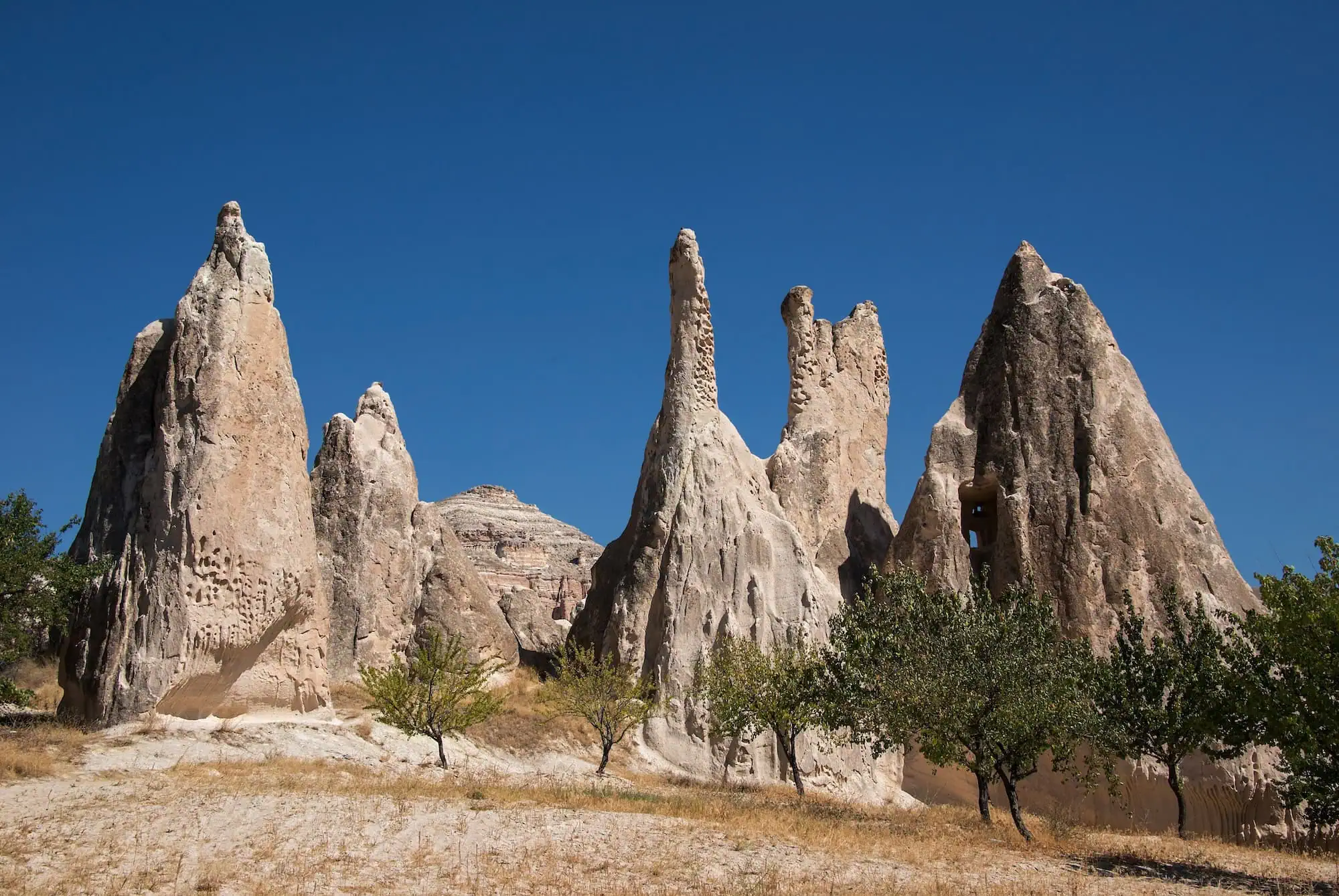 Fairy chimney rock formations in Red Valley, Cappadocia with carved cave dwellings