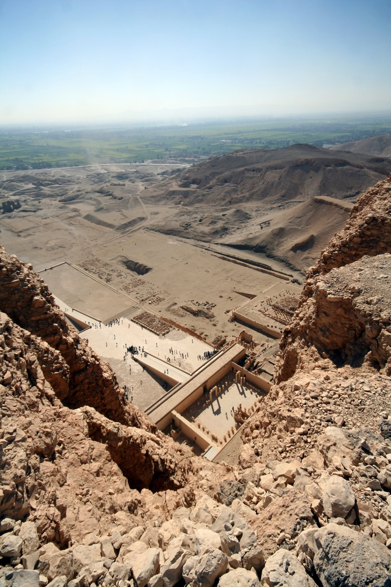 Complejo de templos antiguos egipcios con turistas explorando el sitio arqueológico en el valle desértico
