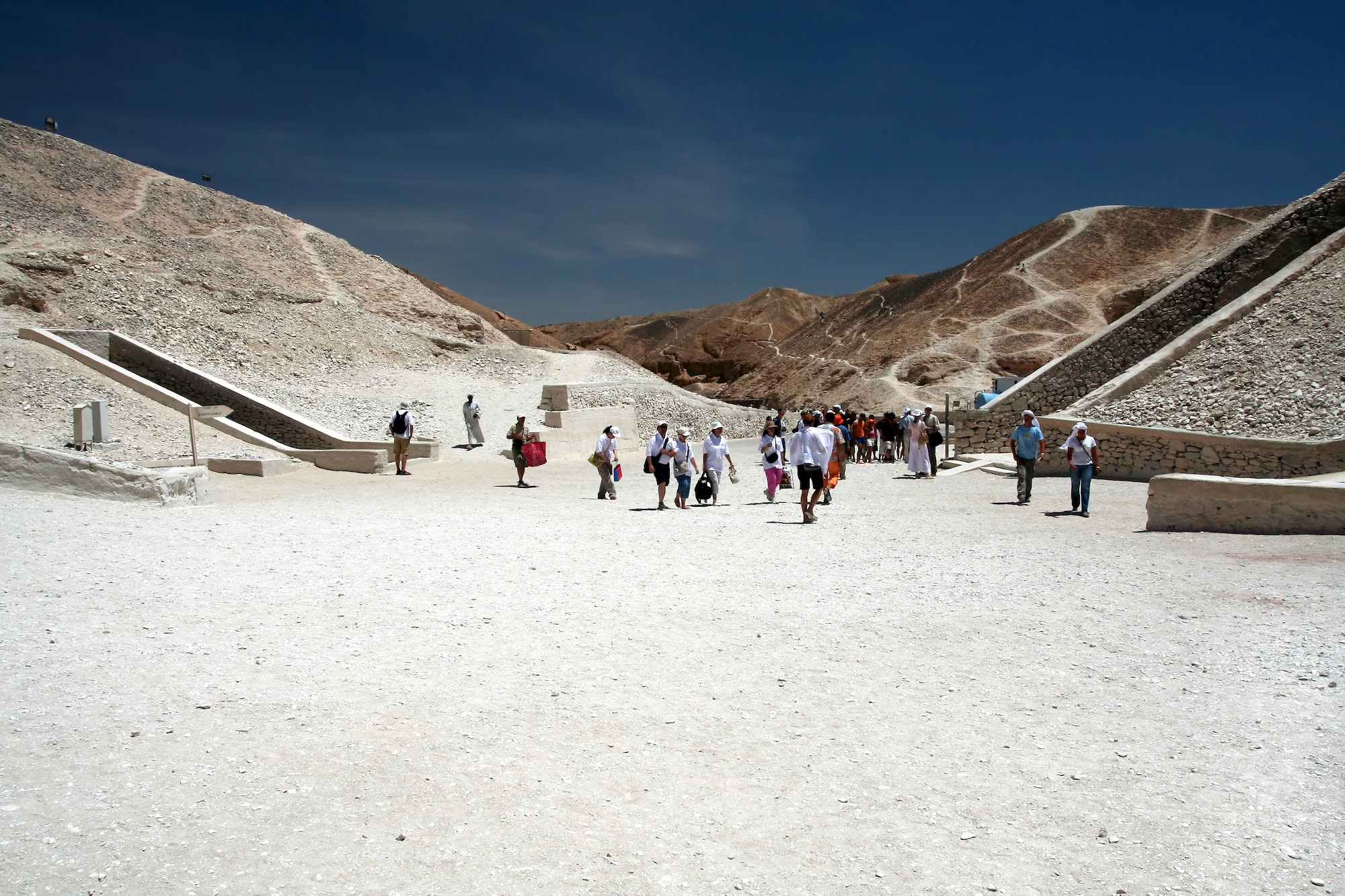 Tourists exploring tomb entrances at Valley of the Kings archaeological site