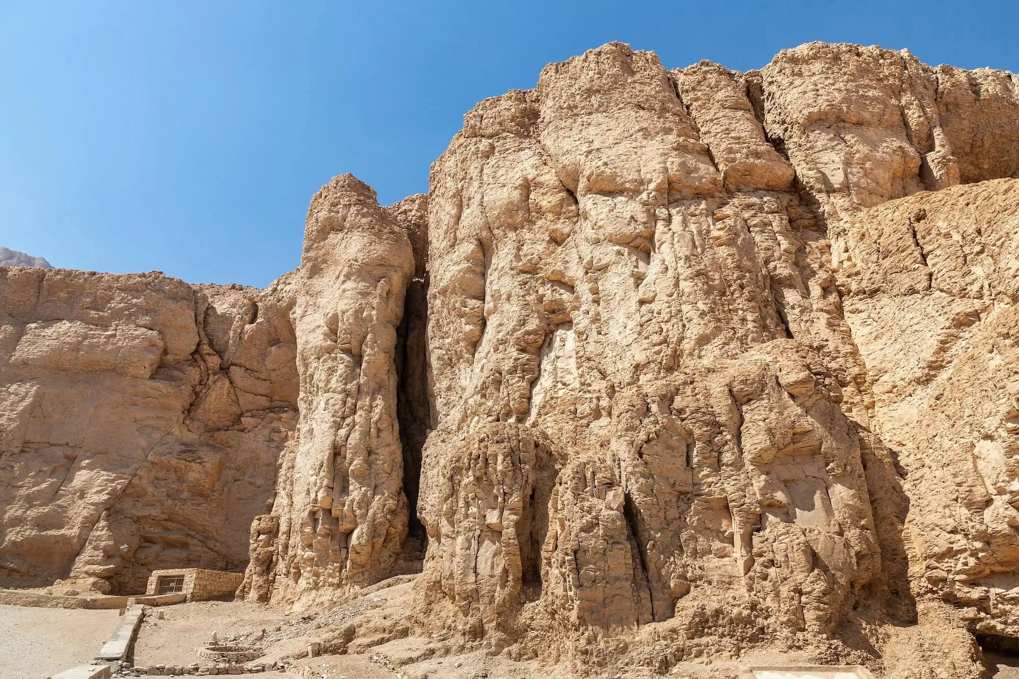 Ancient Egyptian tomb entrance carved into limestone cliff in Valley of the Kings