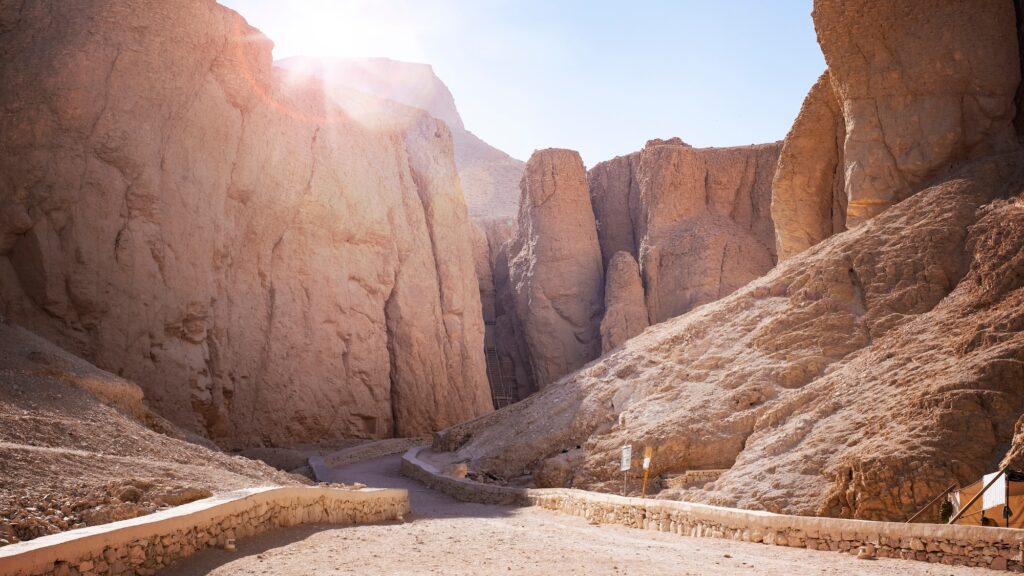 Rock-cut tomb entrances and surrounding desert hills at sunrise in the Valley of the Kings, Luxor