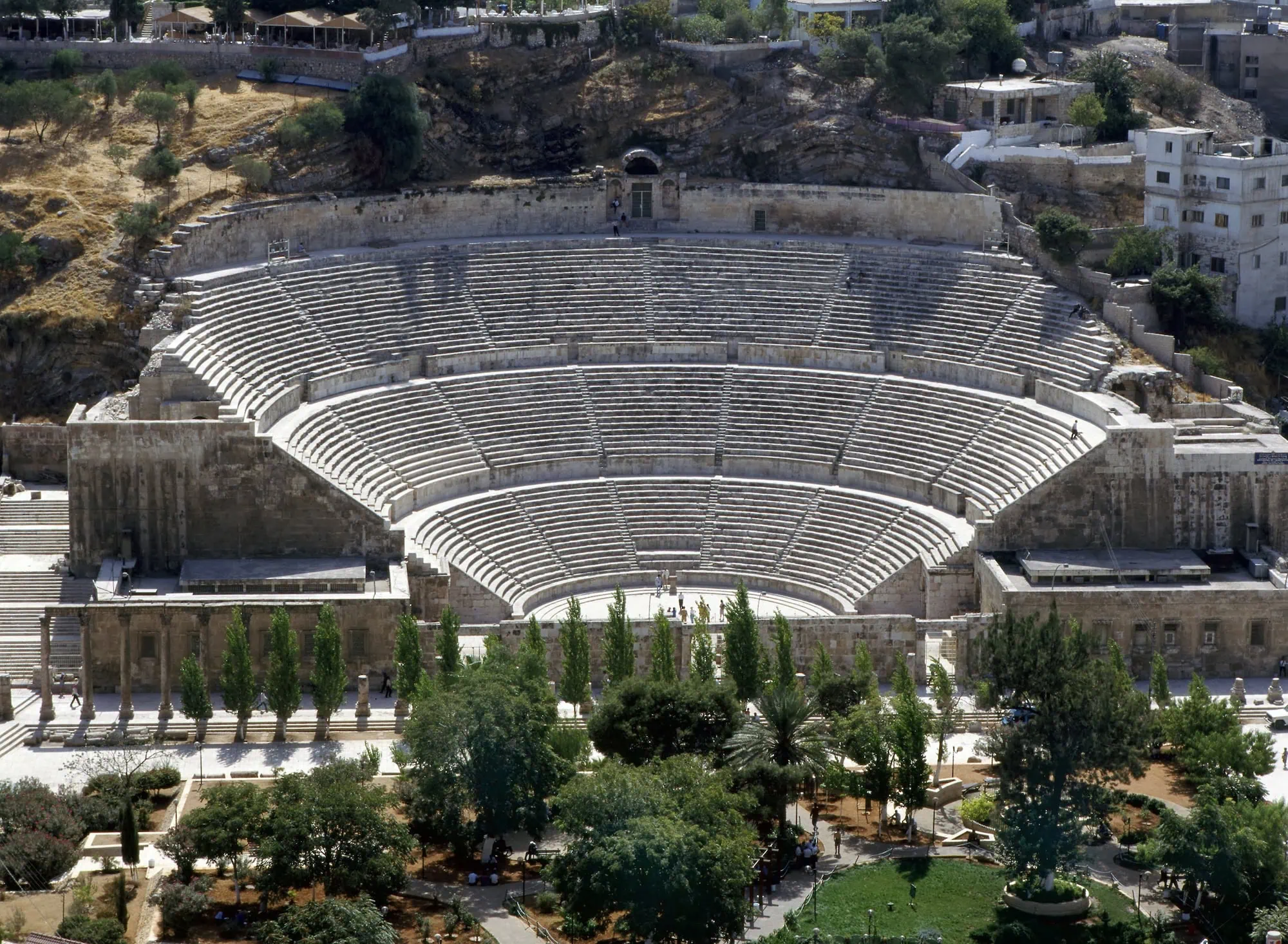 Restored Roman Theatre in Amman showing ancient stone seating and modern city backdrop