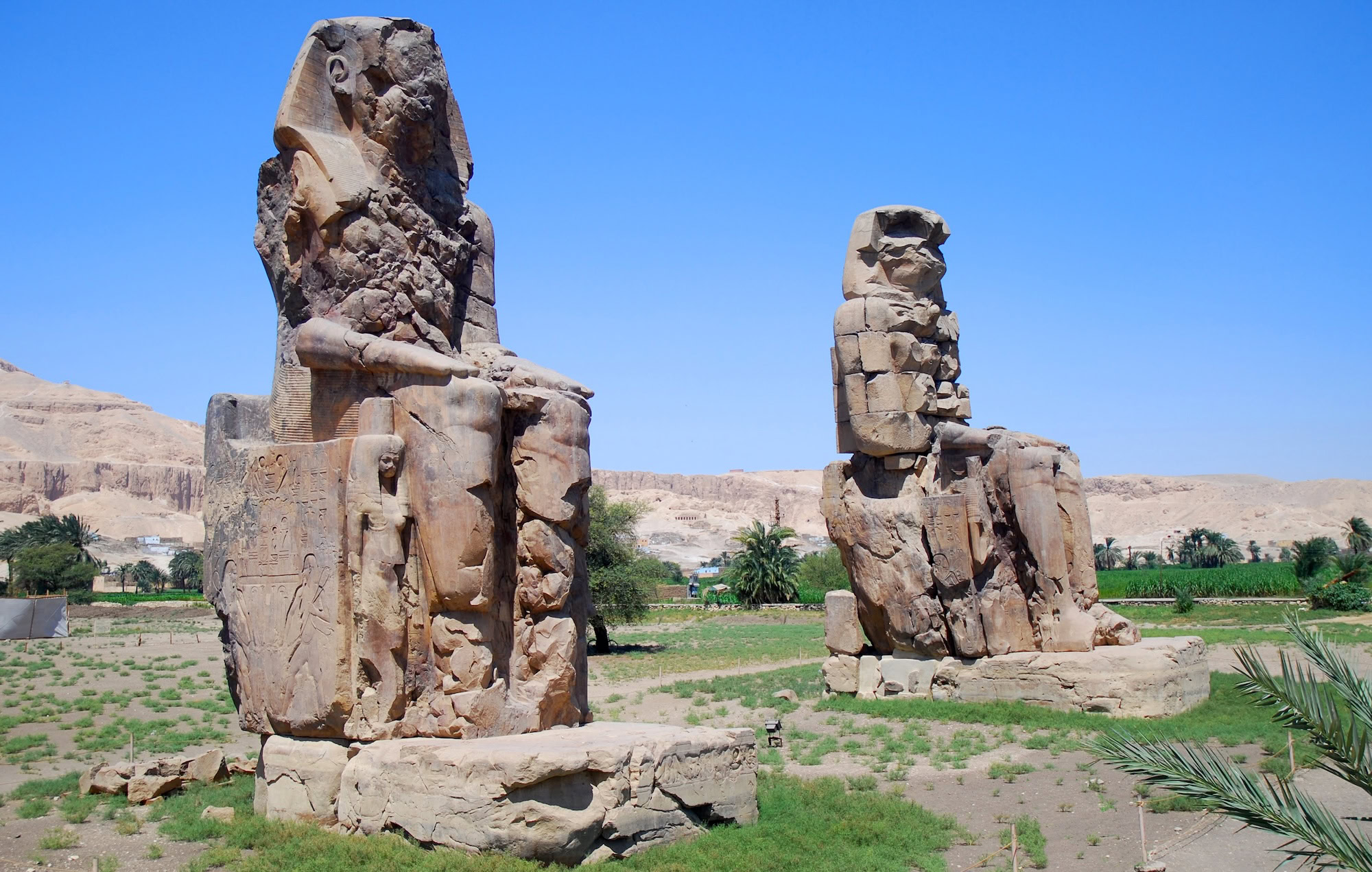 Estátuas colossais sentadas de Amenhotep III com hieróglifos detalhados em Luxor