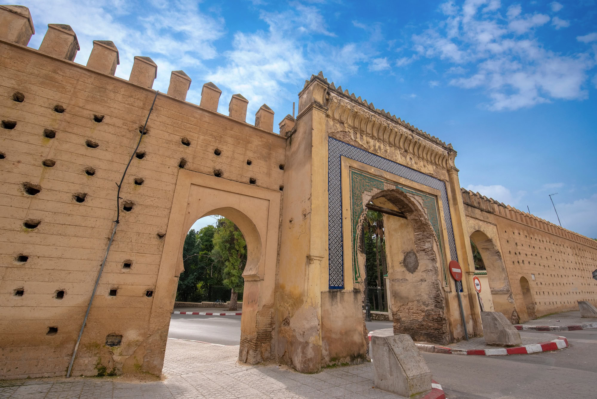 Historic Moroccan city gate with decorative tiles and fortress walls