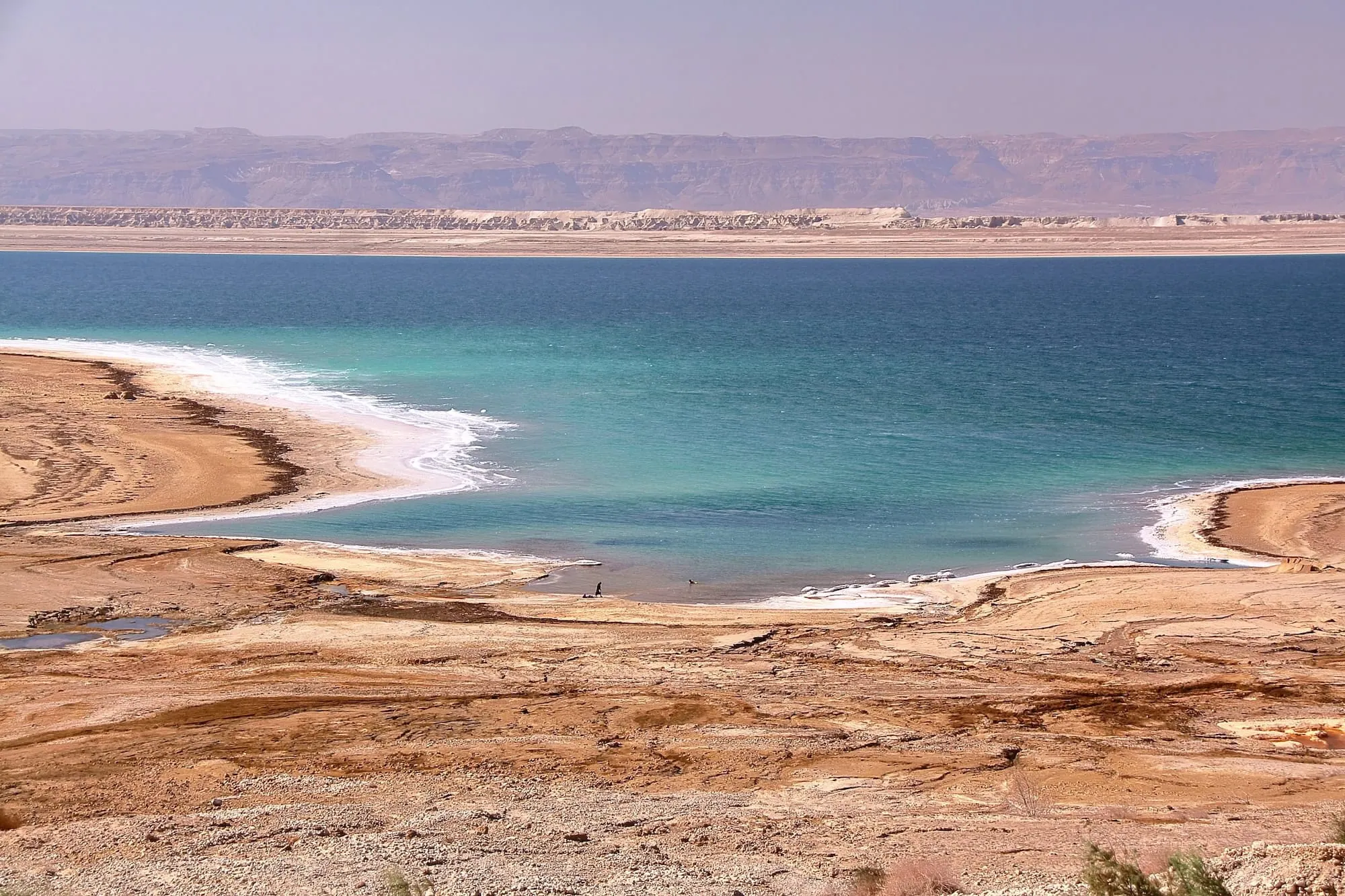 Panoramic view of the Dead Sea with turquoise water and white salt formations