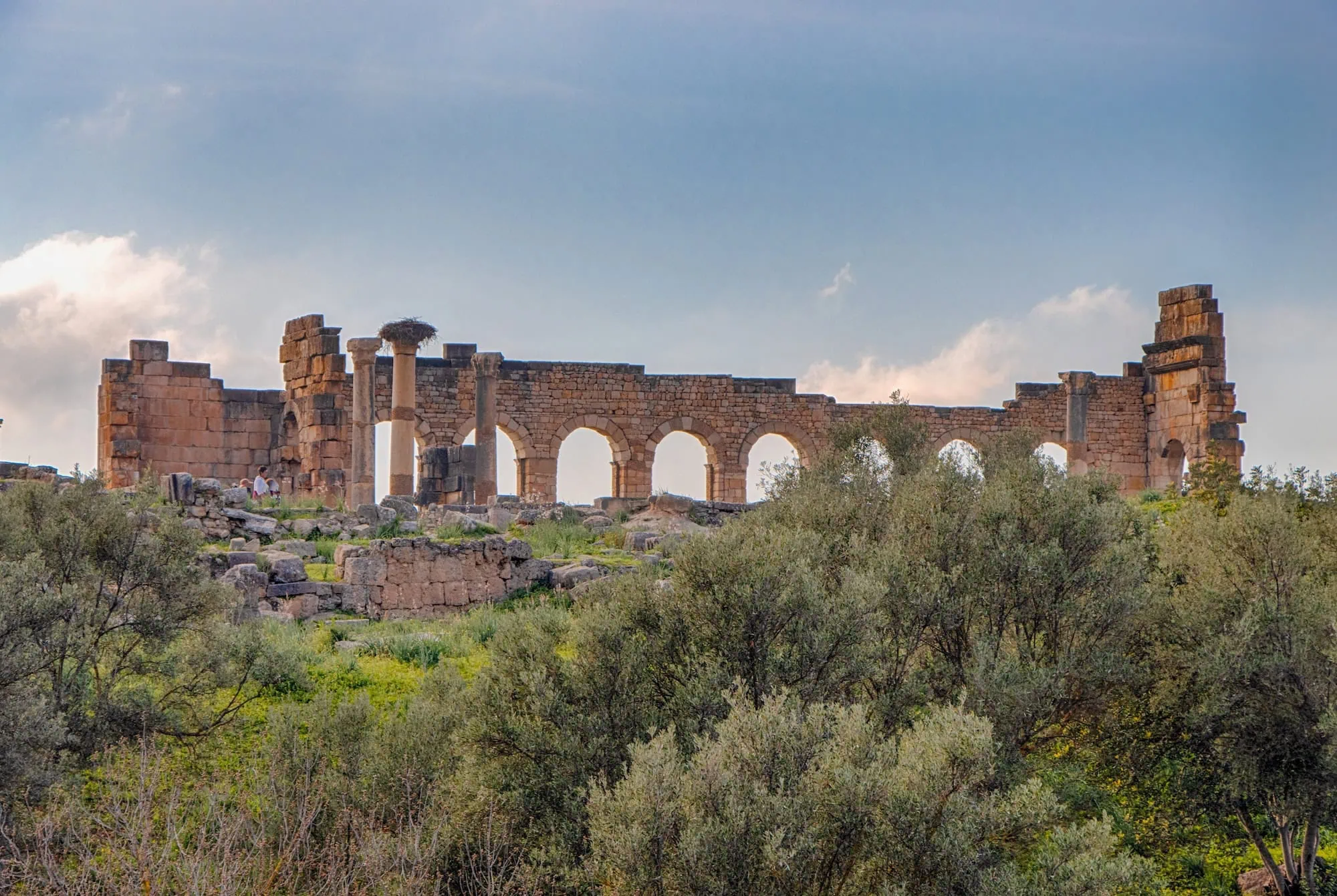Ancient Roman ruins at Volubilis archaeological site near Meknes with stone arches and columns