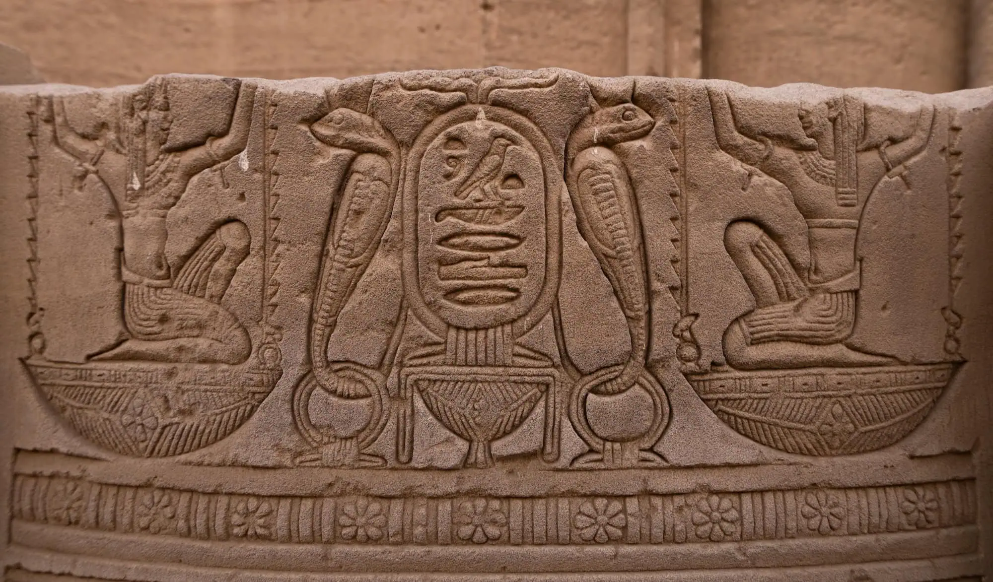 Hieróglifos e relevos egípcios antigos com cartuchos reais e símbolos dinásticos