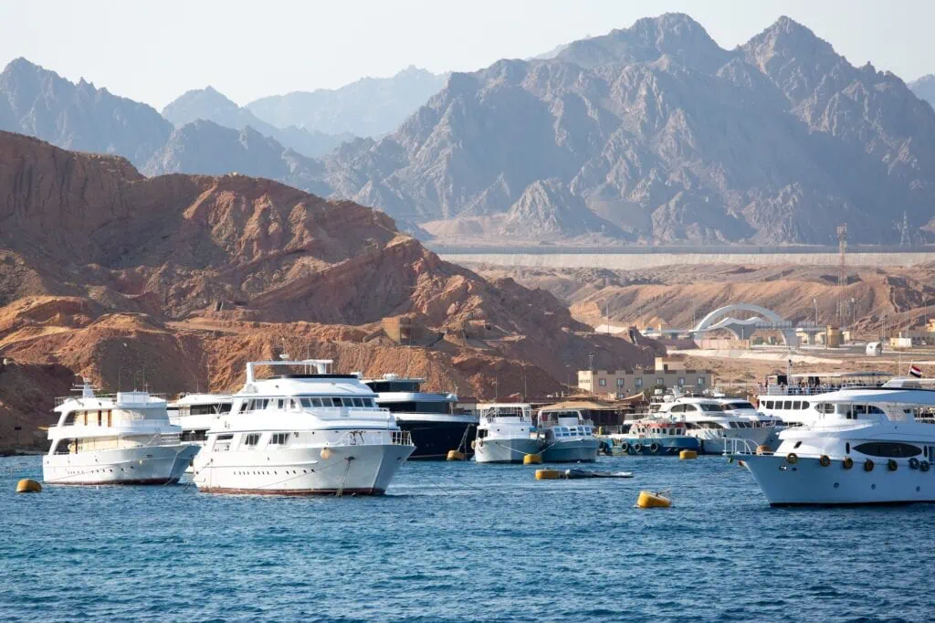 White yachts moored in the harbor with desert hills and mountains in the background, Sharm el Sheikh