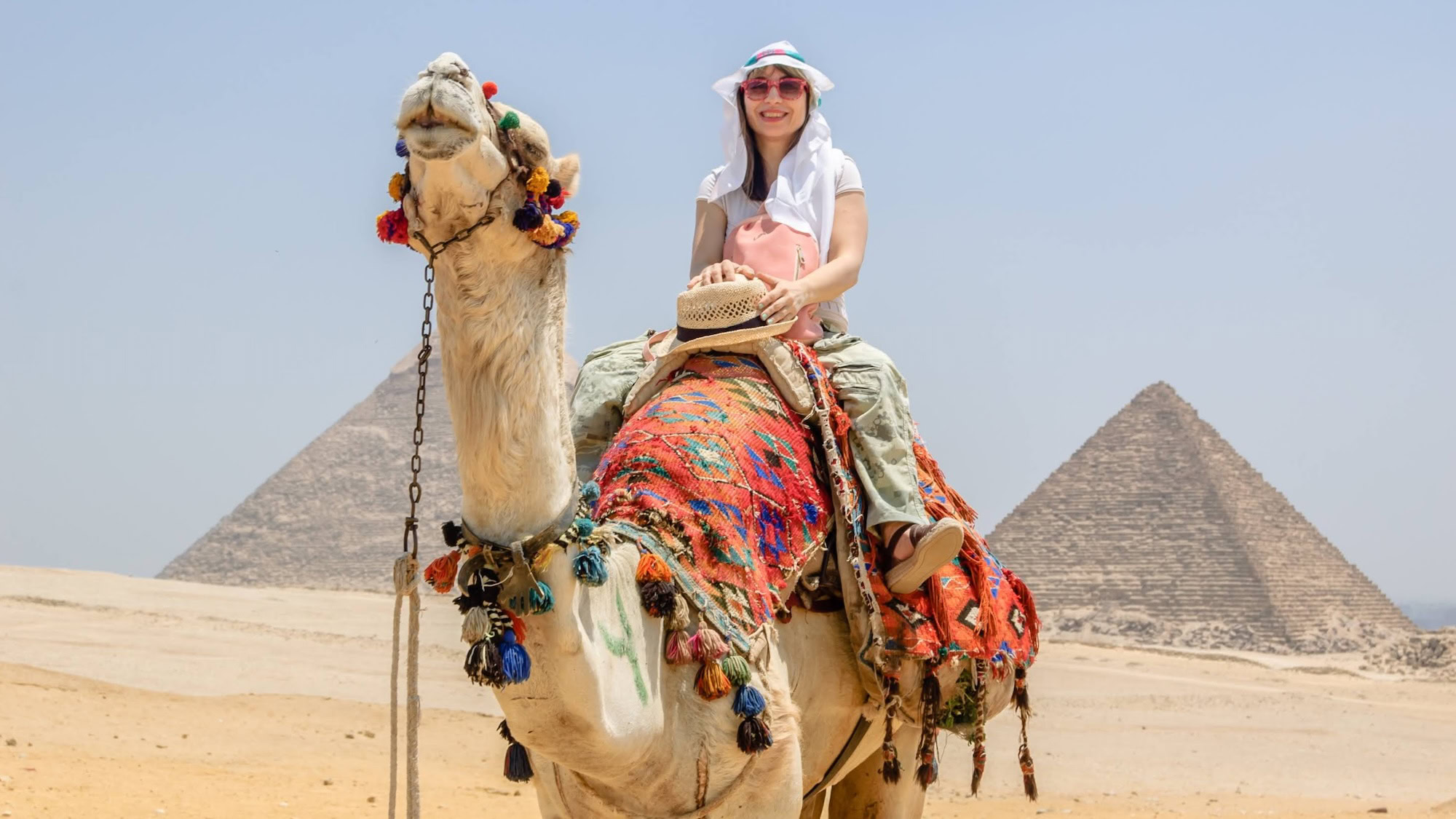 Tourist riding camel near the Great Pyramid of Giza in Egypt