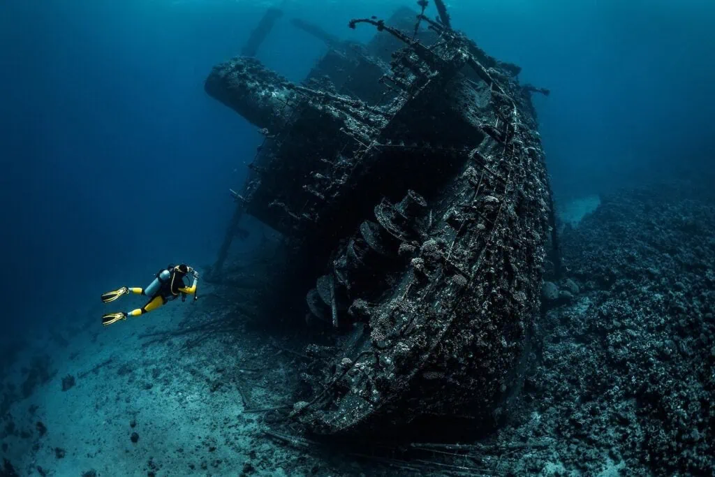 Scuba diver exploring underwater shipwreck