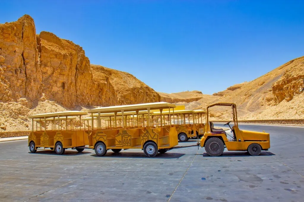 Yellow tourist transport vehicle operating along pathways in the Valley of the Kings, Luxor