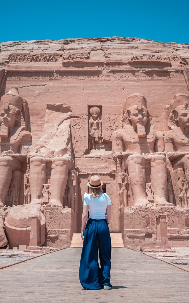 Young girl standing near the rock-cut façade of the Abu Simbel temples during a visit, Abu Simbel