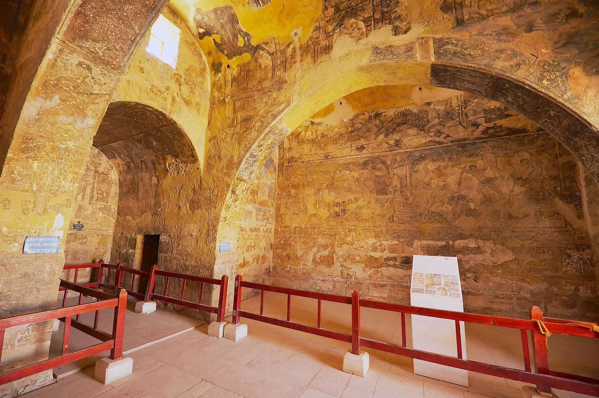 Interior of Qasr Amra showing elaborate Umayyad frescoes on walls and vaulted ceiling