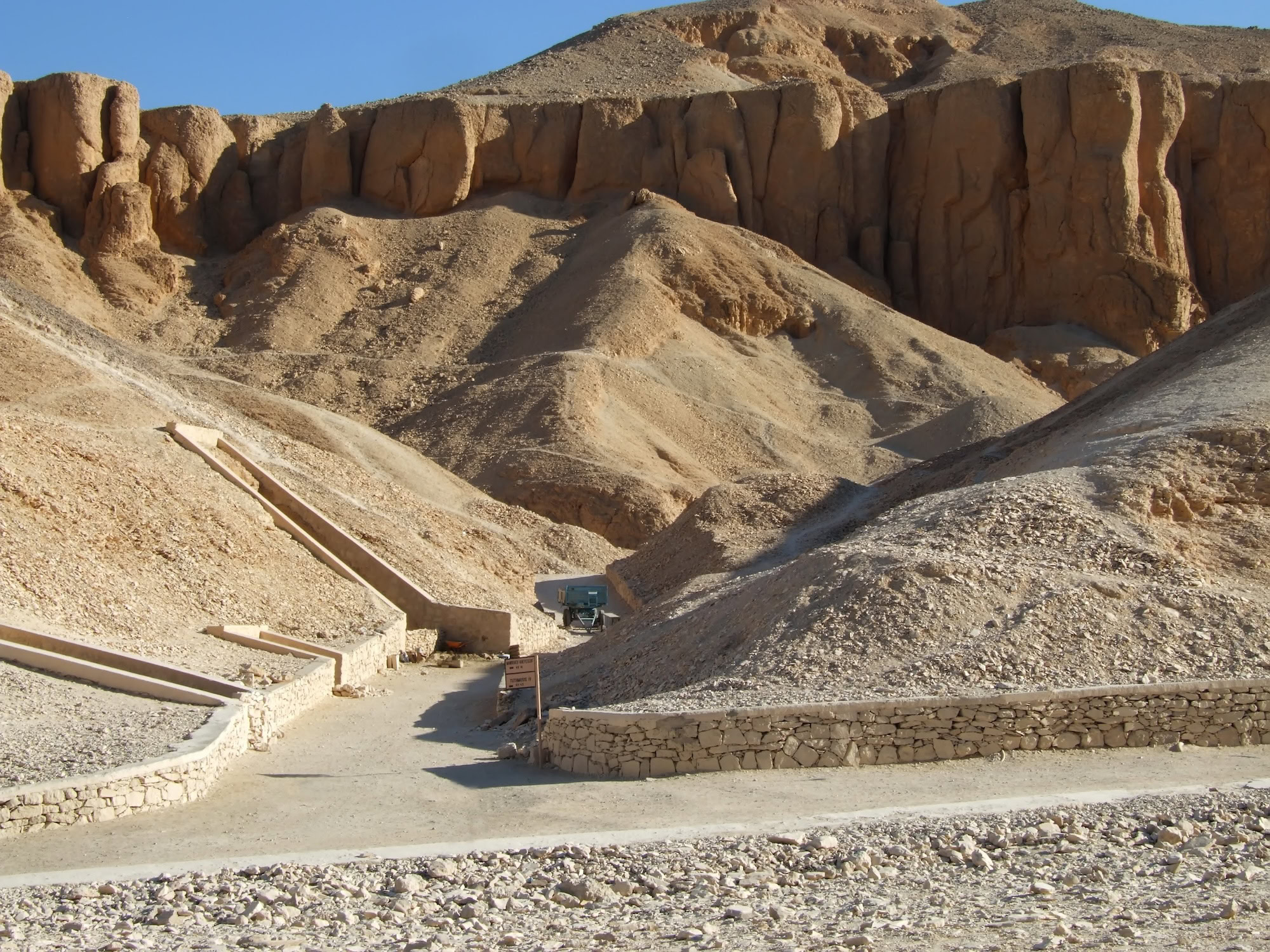 Stone entrance to an ancient tomb in the Valley of the Kings with limestone cliffs