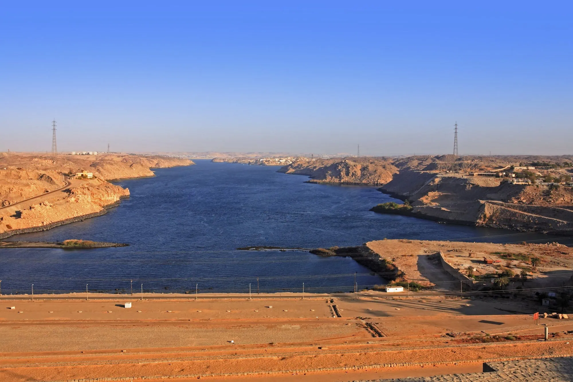 Lake Nasser landscape with desert cliffs and transmission towers in Egypt