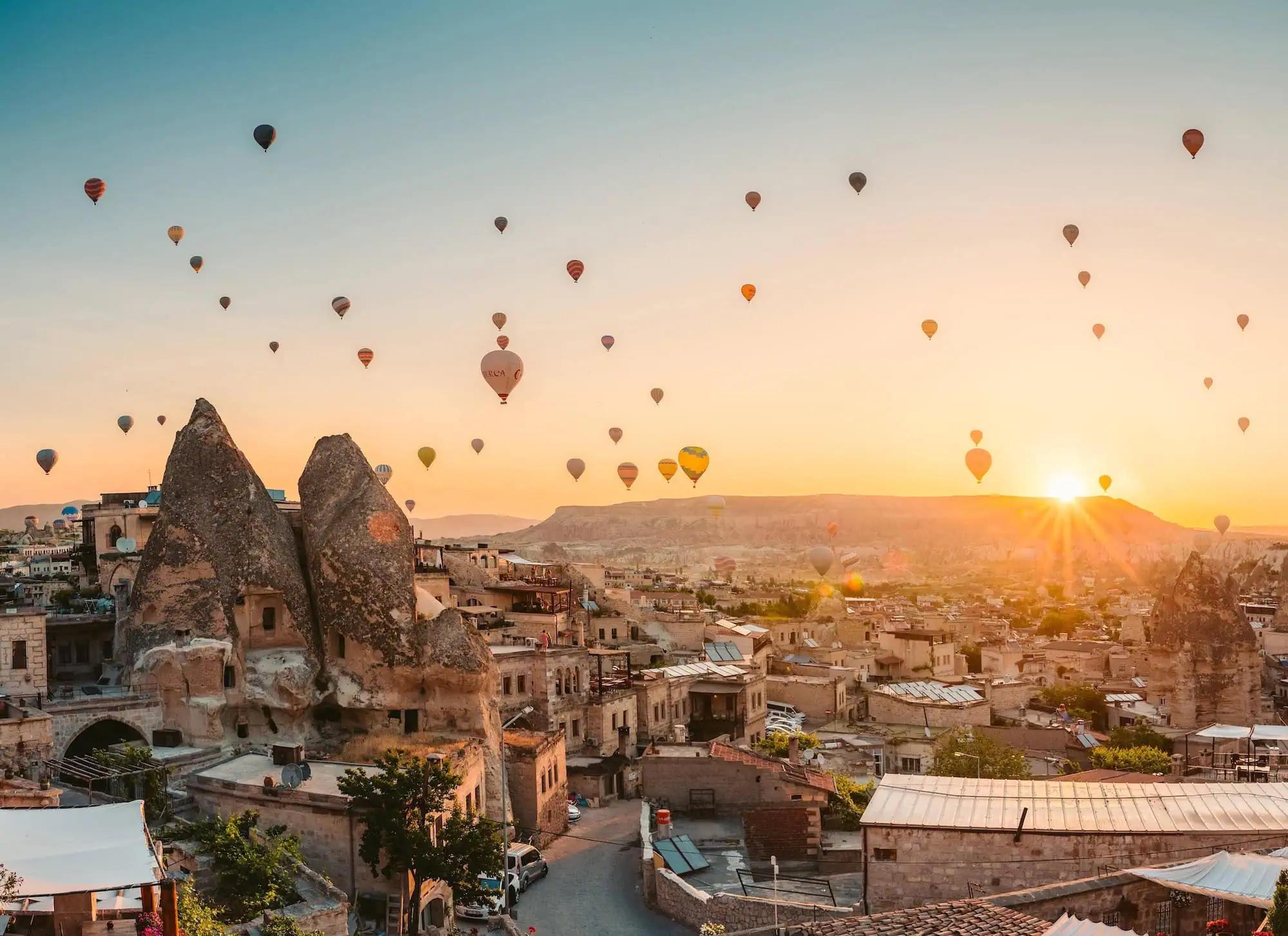 Hot air balloons floating over fairy chimneys at sunrise in Cappadocia, Turkey
