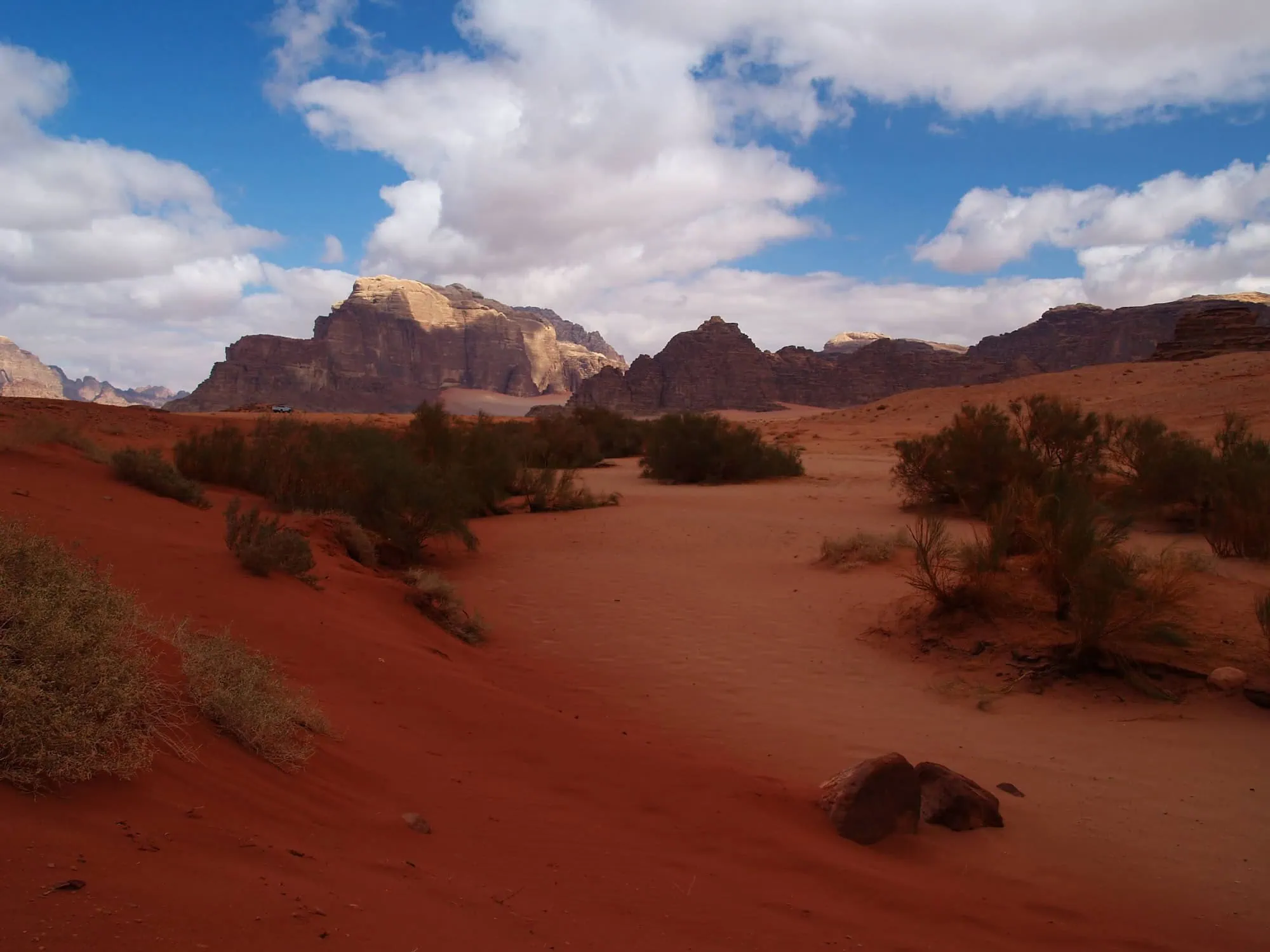 Dramatic red sand dunes and sandstone rock formations in Wadi Rum desert, Jordan