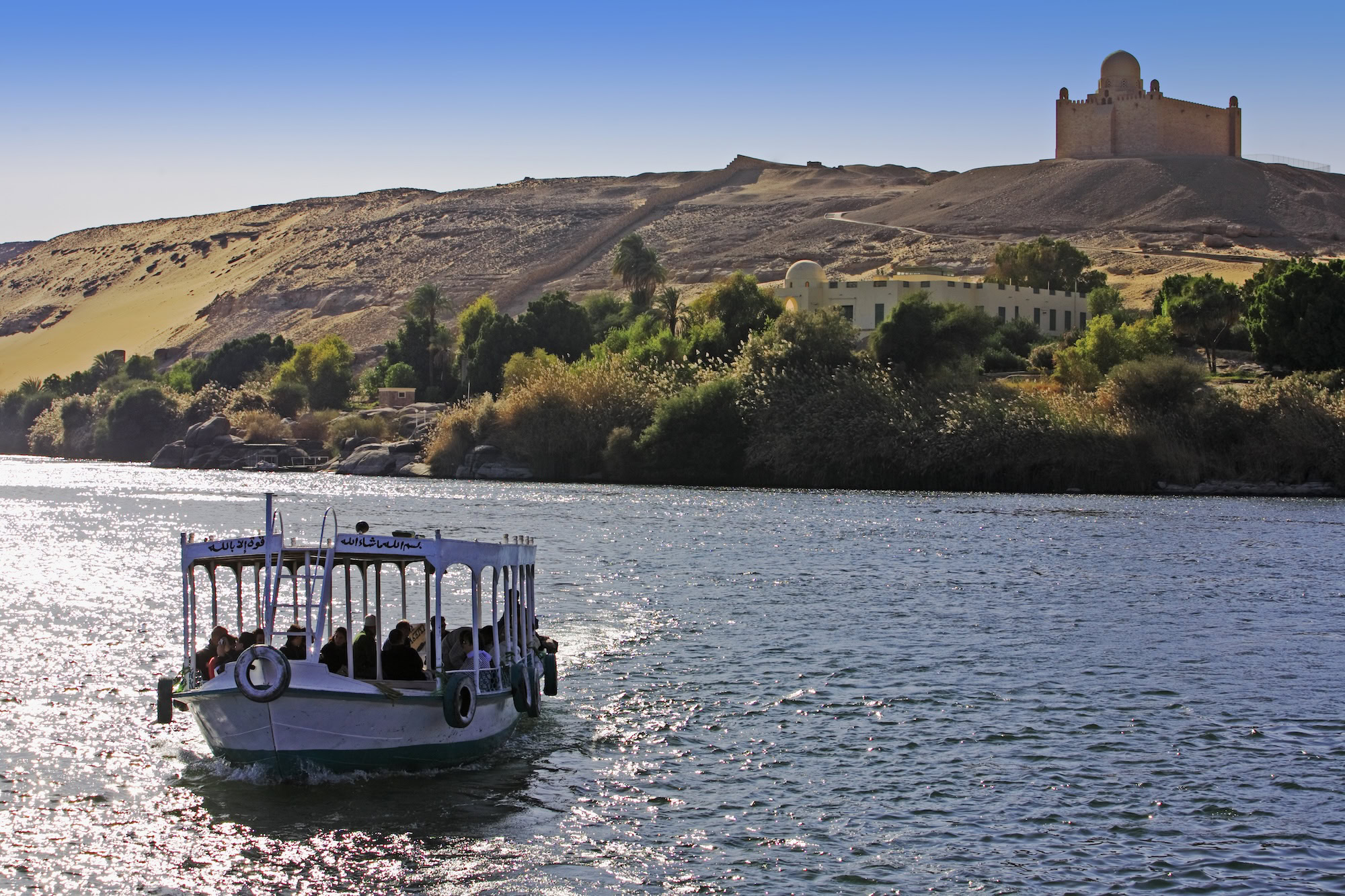 boat cruising on the river nile with Aga Khan tomb on the shore near aswan in egypt 3