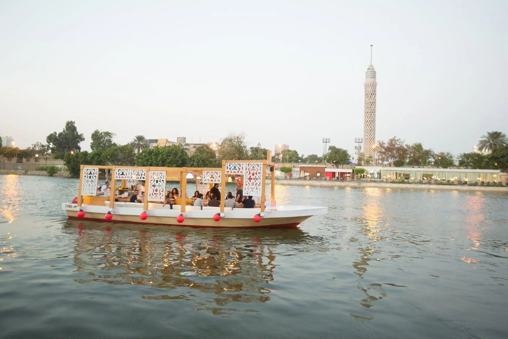 Barco de pasajeros navegando por el río Nilo con la Torre de El Cairo al fondo