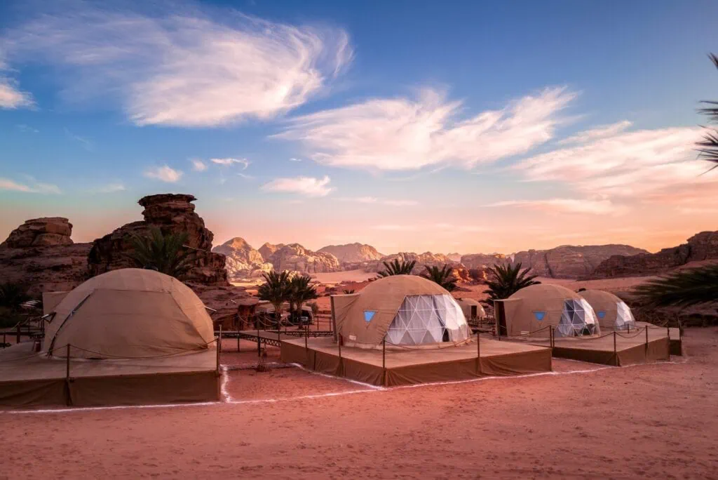Camping tents set on open desert sand with rock formations in Wadi Rum, Wadi Rum