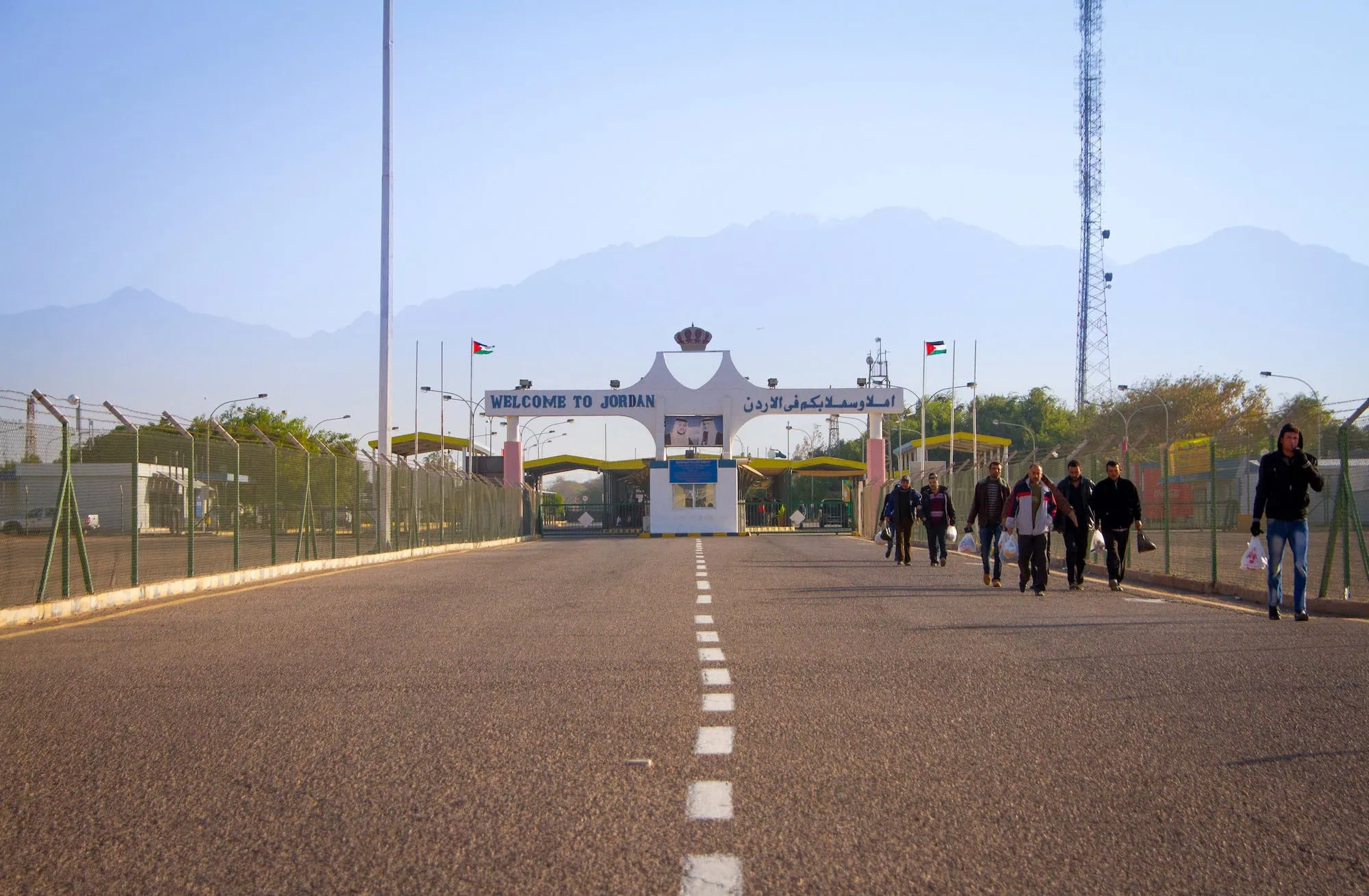 Border crossing checkpoint between Israel and Jordan with welcome gate and mountain landscape