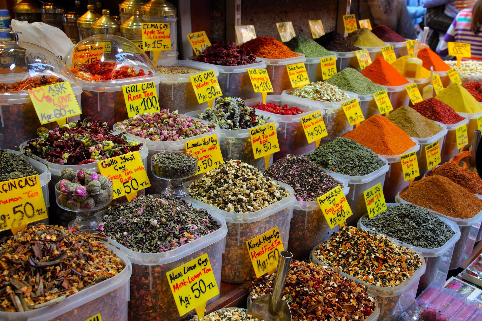 Colorful spice market stall with various herbs and spices in containers
