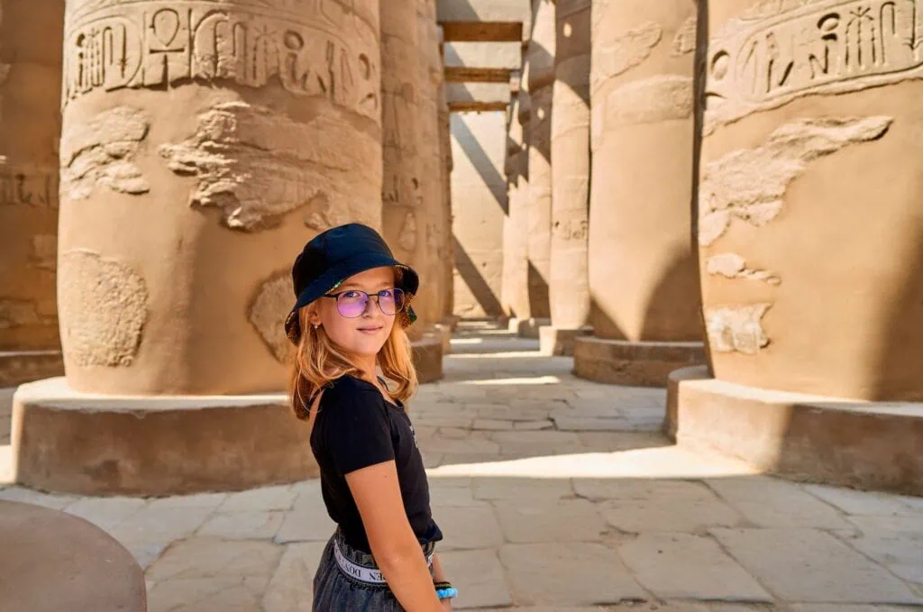 Chica caminando entre las columnas del templo de Karnak en Luxor