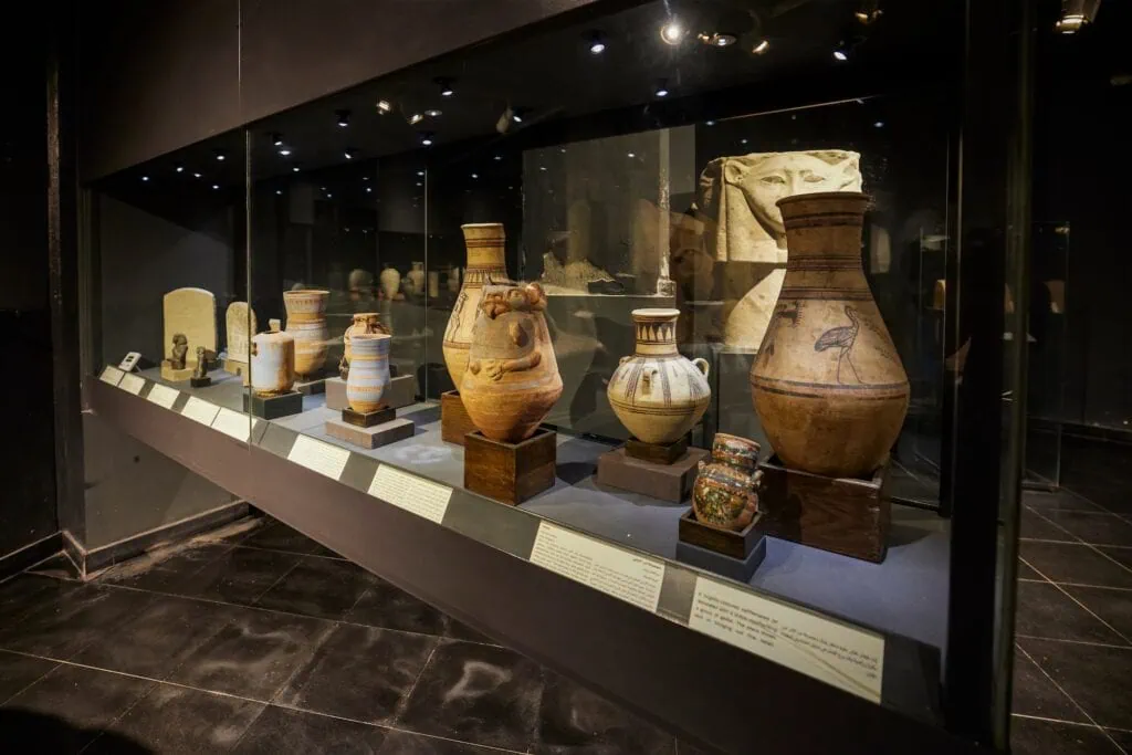 Ceramic jars and vases displayed in glass cases inside the National Museum of Alexandria, Alexandria