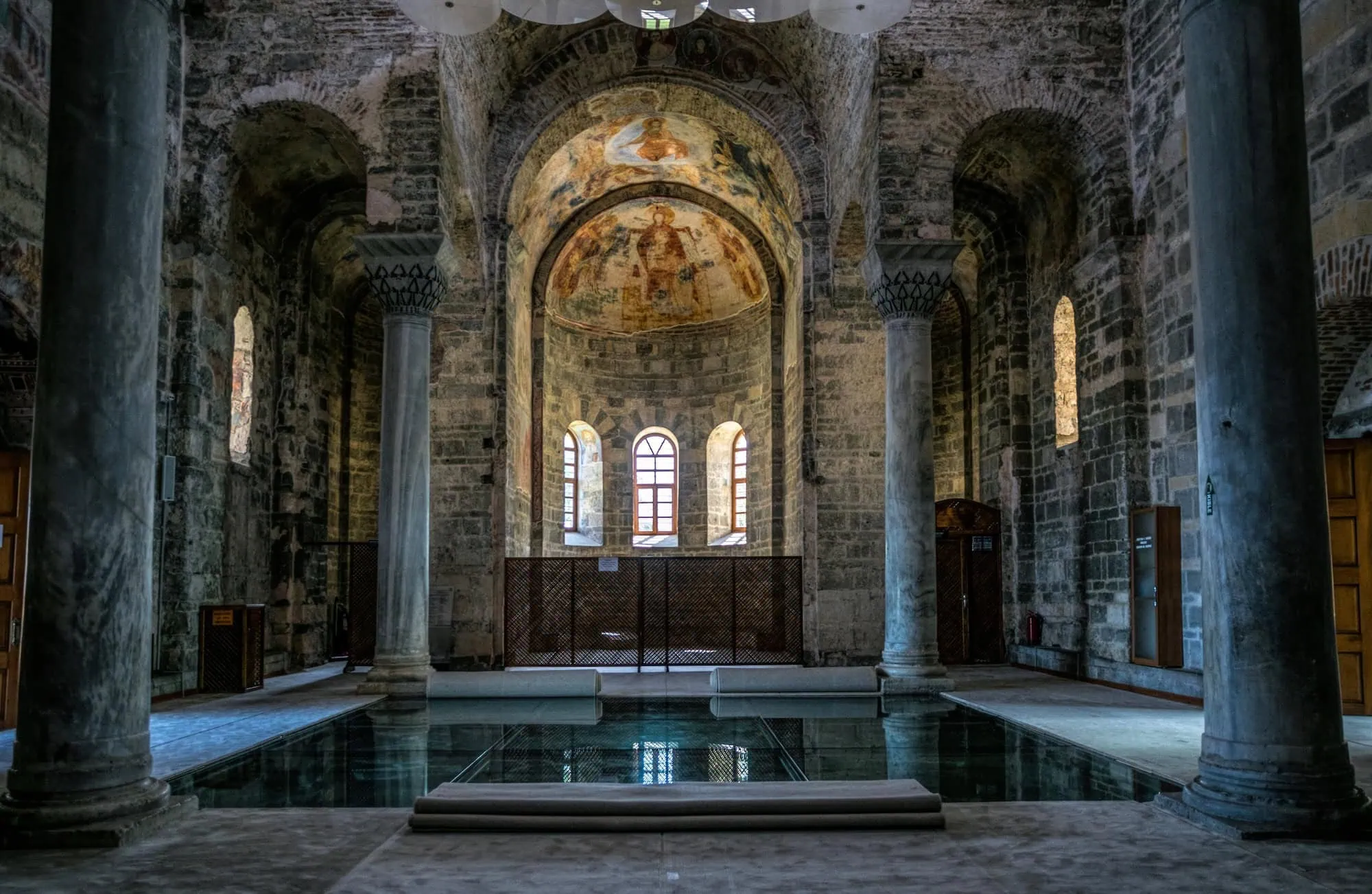Interior view of Hagia Sophia showing Byzantine stone arches, columns and religious frescoes