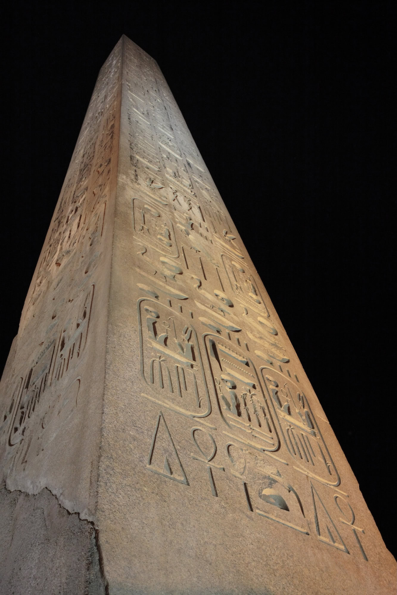 Ancient Egyptian obelisk with carved hieroglyphics standing as monolithic stone monument
