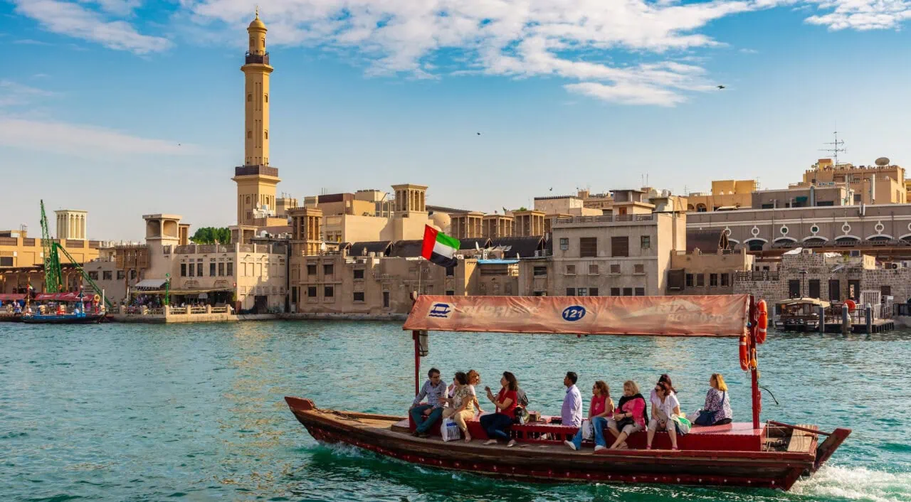 A boat with people on it in front of a city.