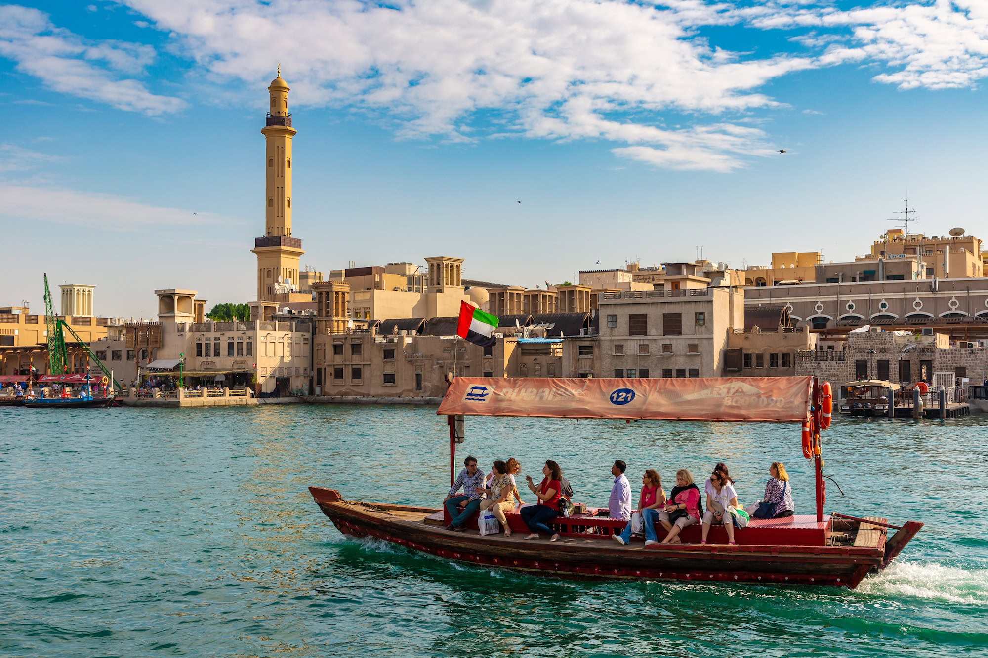 A boat with people on it in front of a city.