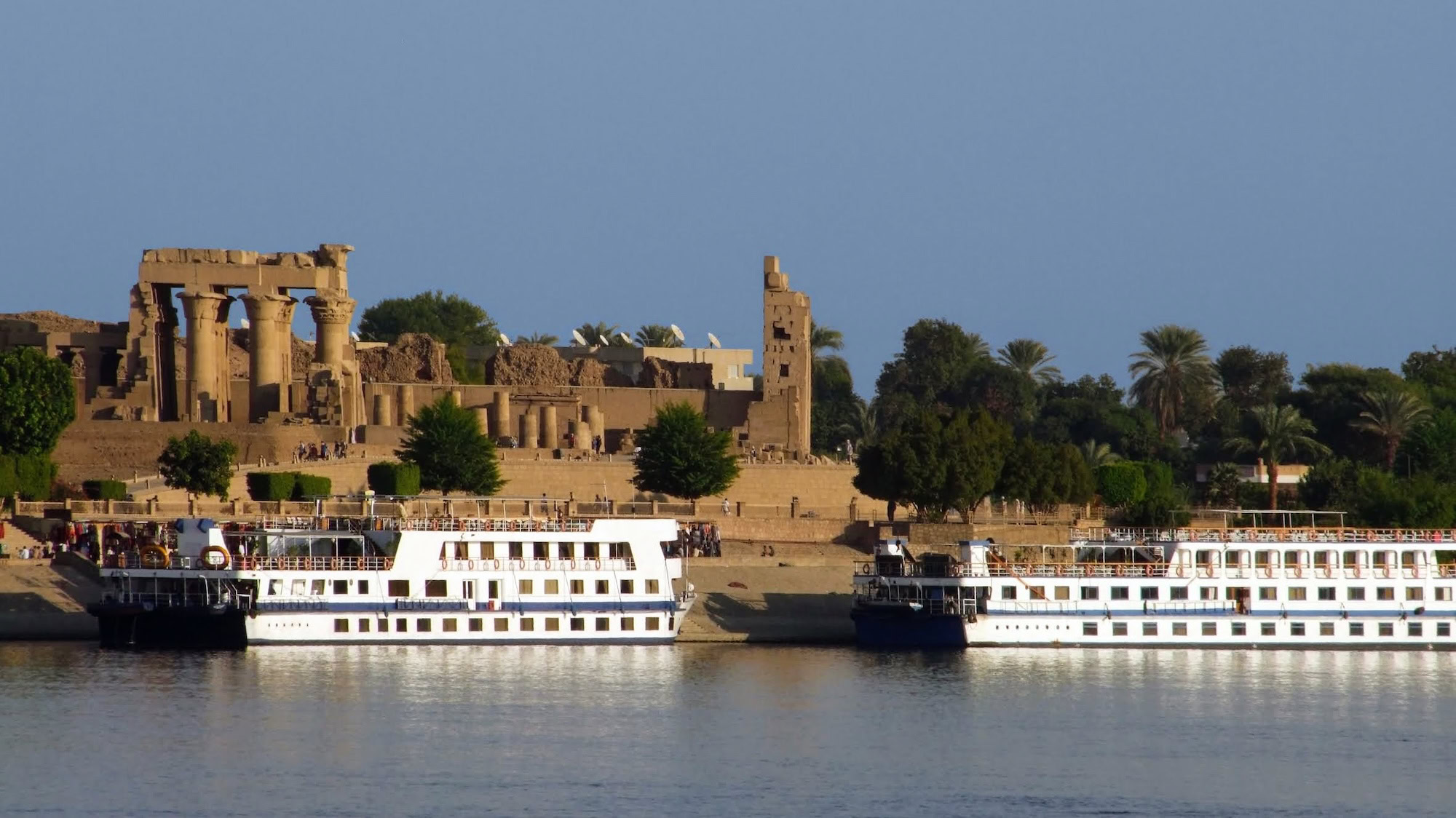 Ancient Kom Ombo Temple ruins viewed from the Nile River with cruise ships